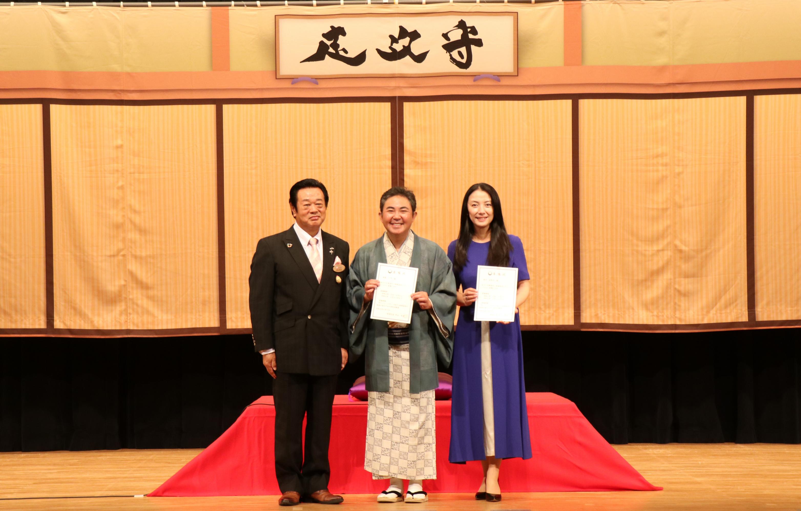 エヴァンジェリストに委嘱いた際の、町長、林家三平さん、国分佐智子さんの集合写真。 エヴァンジェリストに委嘱いた際の、町長、林家三平さん、国分佐智子さんの集合写真。
